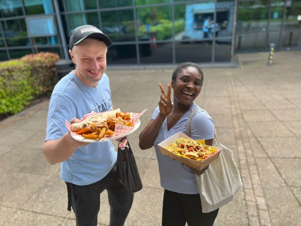 Delicious catered food being enjoyed outdoors by happy people, perfect for events and gatherings.