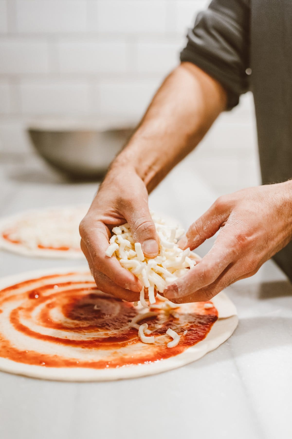 Freshly making pizza with cheese toppings at KK Catering, expert catering service UK.