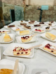 Delicious cheesecake slices with berries, served on white disposable trays at KK Catering event.