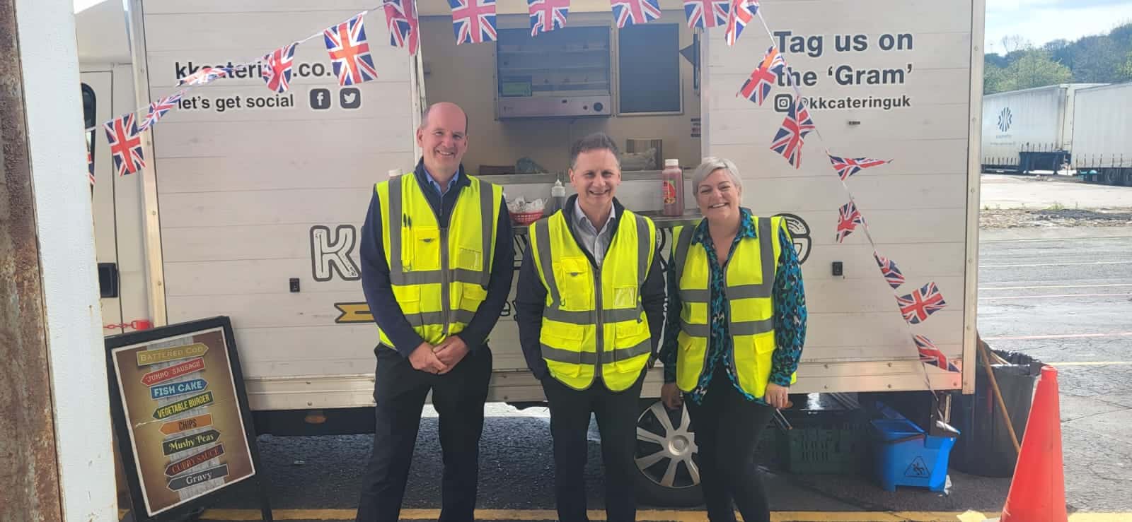 construction workers in high vis vest infront of a kk catering van