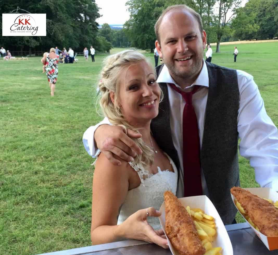 Happy couple enjoying fish and chips from KK Catering's wedding fish and chip van.