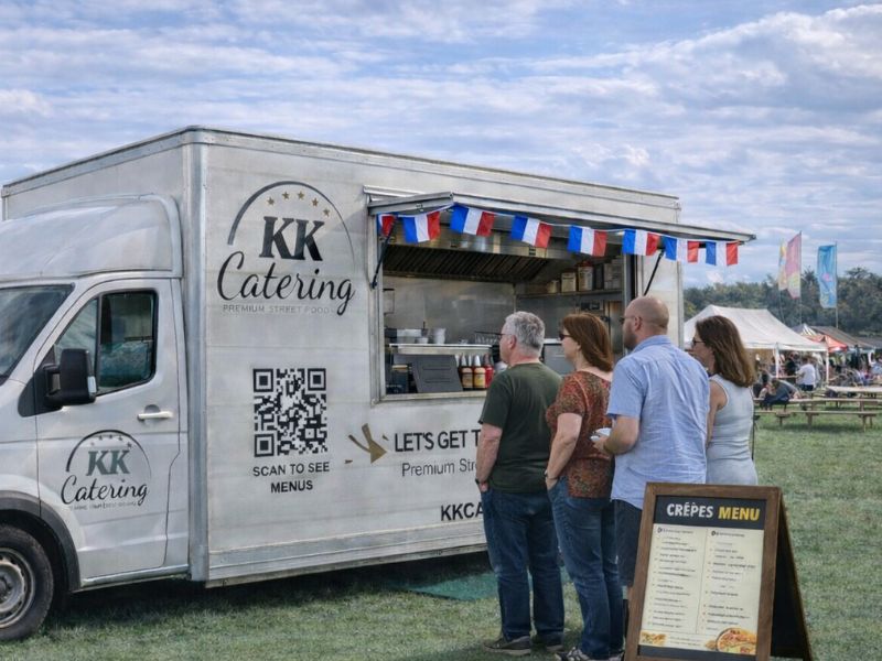 Freshly prepared crepes served from a mobile catering van at an outdoor event.