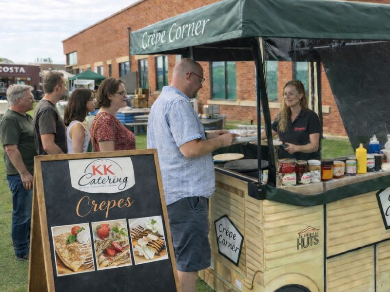 Freshly made crepes served at KK Catering crepe stand in a busy outdoor setting.