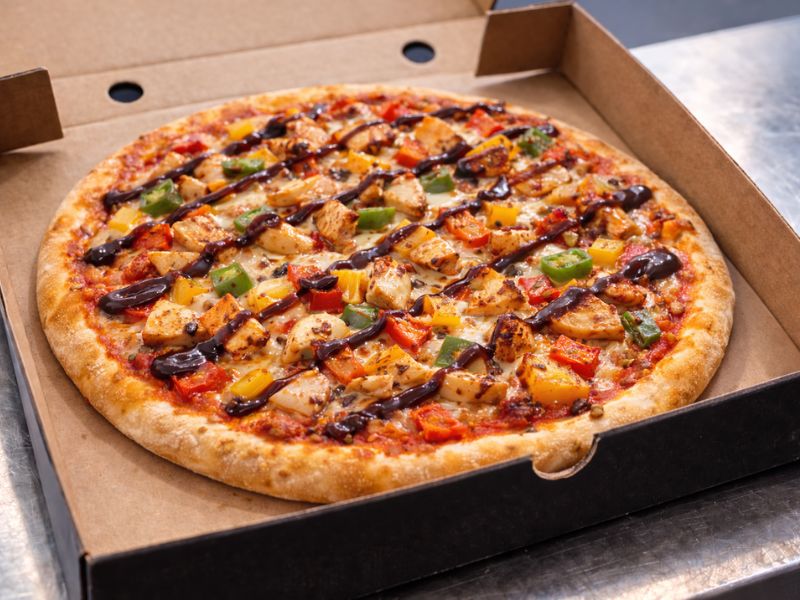 Finger-Licking Fire-Grilled Fiesta pizza with BBQ chicken and mixed peppers from KK Catering pizza van hire.