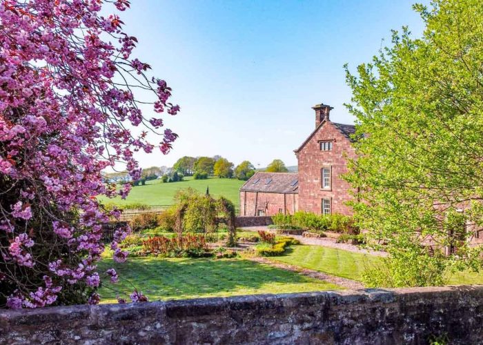 Beautiful spring garden at Toft Estate wedding venue with blooming trees and historic building.