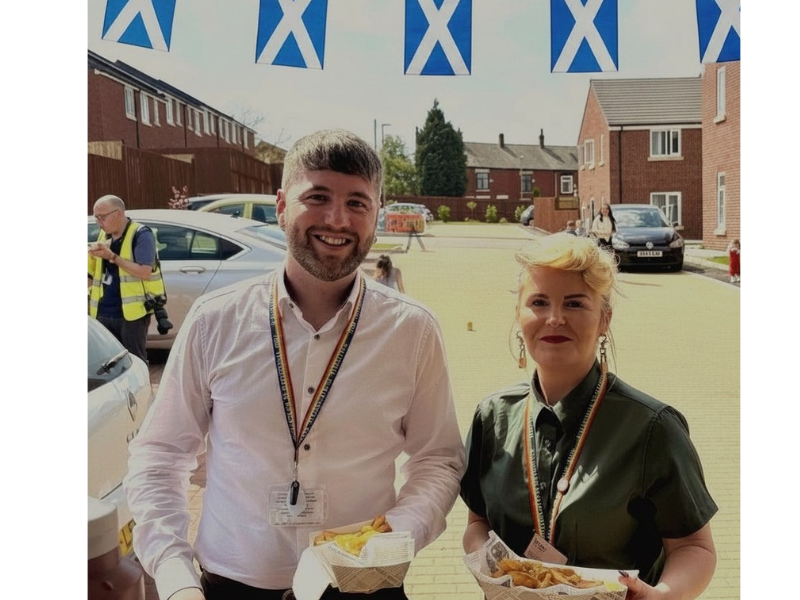 Two guests enjoying fish and chips under Saltire bunting at a Glasgow outdoor event catered by KK Catering