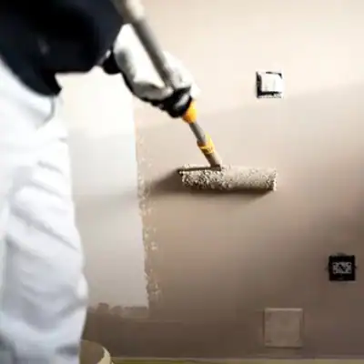 Paint roller applying primer to wall in home renovation, interior decorating service.