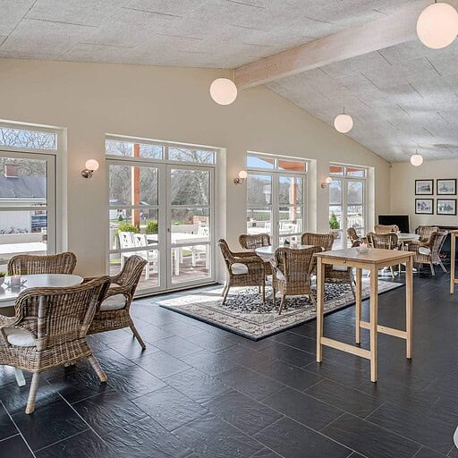 Behageligt spiserum i Knudhule Badehotel med store vinduer og moderne indretning.