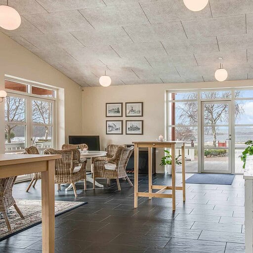 Lyst indendørskøkken med naturudsigt og rustikke møbler på Knudhule Badehotel.