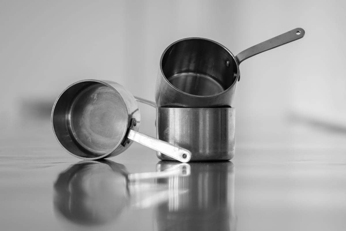 Rustne metalmåtter på bord, køkkenudstyr, enkel sort-hvid billedkomposition.