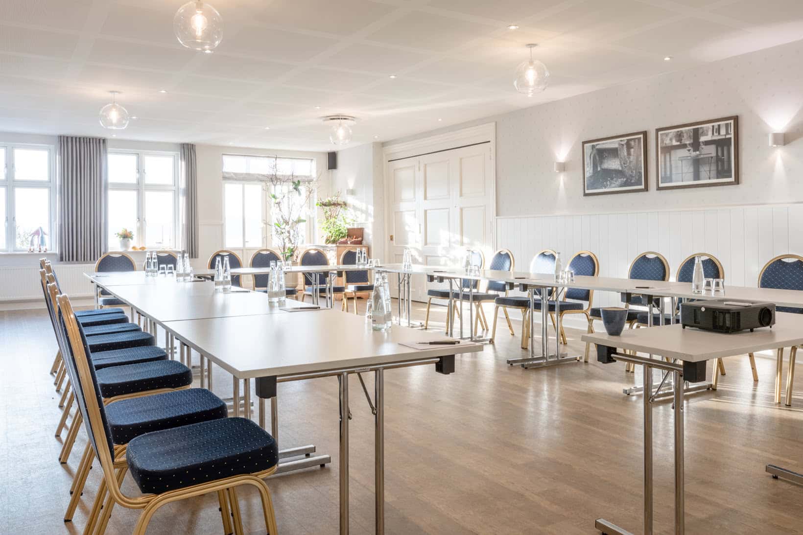 Lyst konferencelokale med store vinduer og moderne møbler på Knudhule Badehotel.