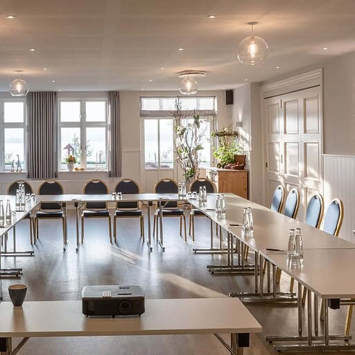 Fredet mødelokale i Knudhule Badehotel med store vinduer og moderne indretning.