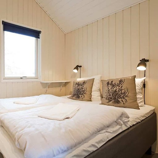 Hyggeligt hotelværelse med komfortabel seng og privat badeværelse på Knudhule Badehotel.