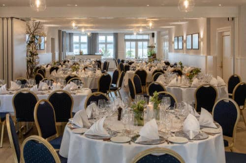 Elegant festlokale med borddækning til arrangementer og events på Knudhule Badehotel.