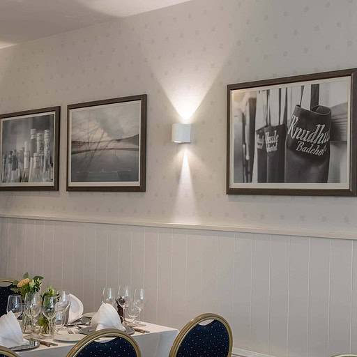 Køkken-inspirertid indretning med billeder og blå stole til en hyggelig badehoteloplevelse.