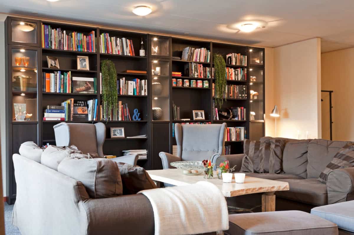 Hyggeligt loungeområde i Knudhule Badehotel med komfortable sofaer og en stor bogreol.