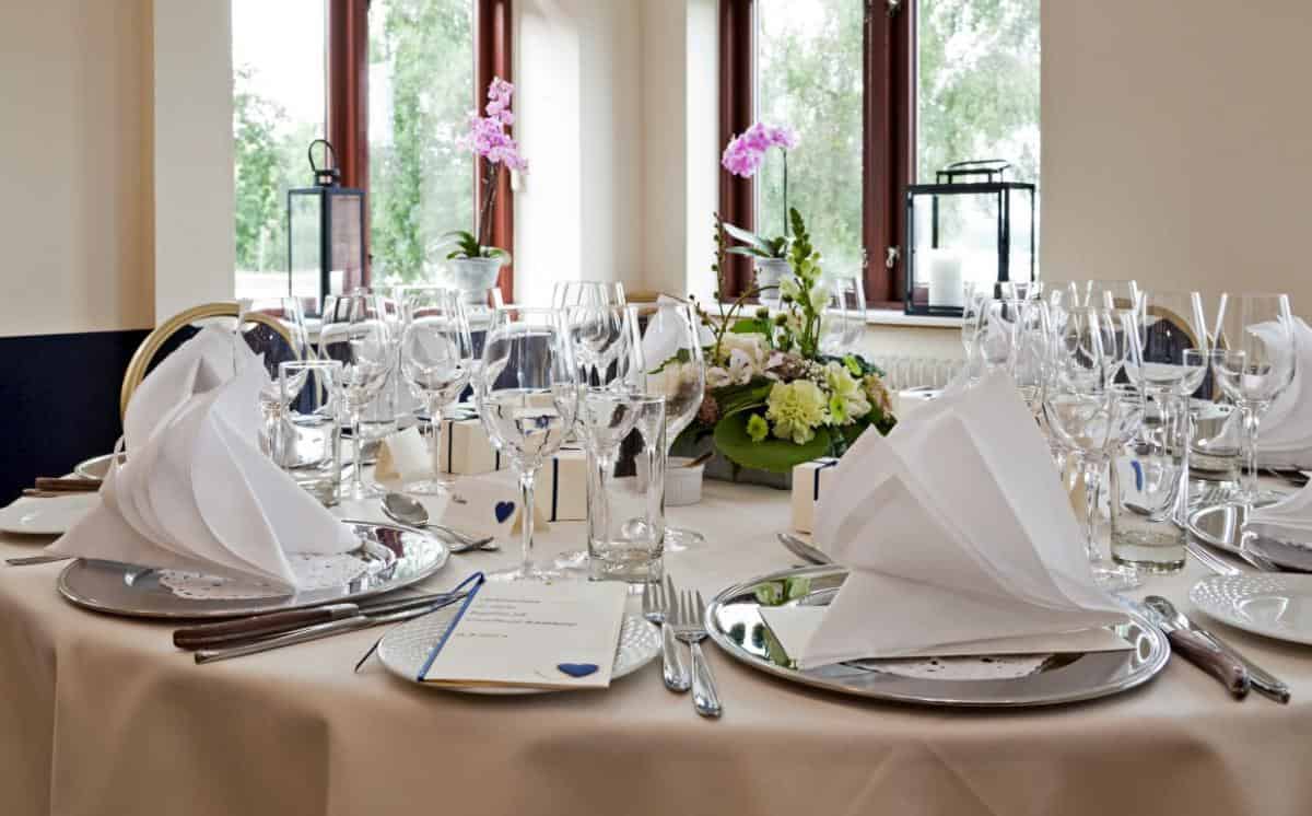 Elegant festtallerken med glas, bestik og blomsterdekoration til bryllup eller fest på Knudhule Badehotel.
