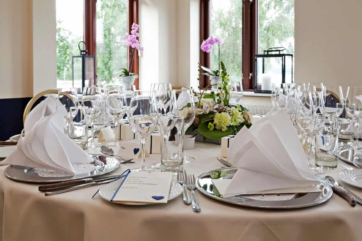 Elegant festbord med blomsterdekoration til arrangement på Knudhule Badehotel.