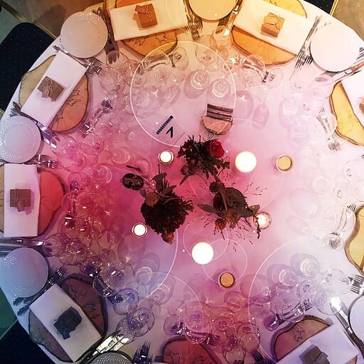 Elegant festtafel med glas, lysestager og blomster til arrangement hos Knudhule Badehotel.