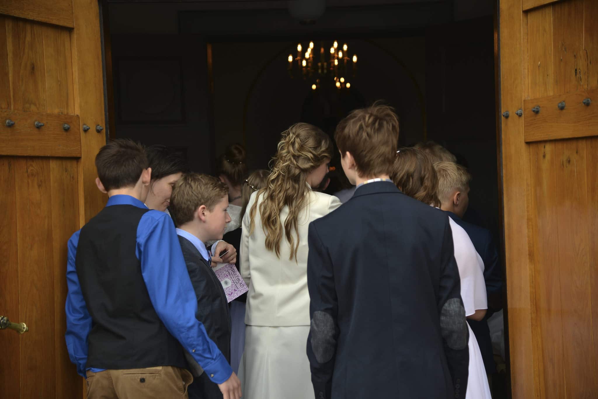 Elegant ungdomsgæster ved ankomsten til Knudhule Badehotel, smuk træindgang.