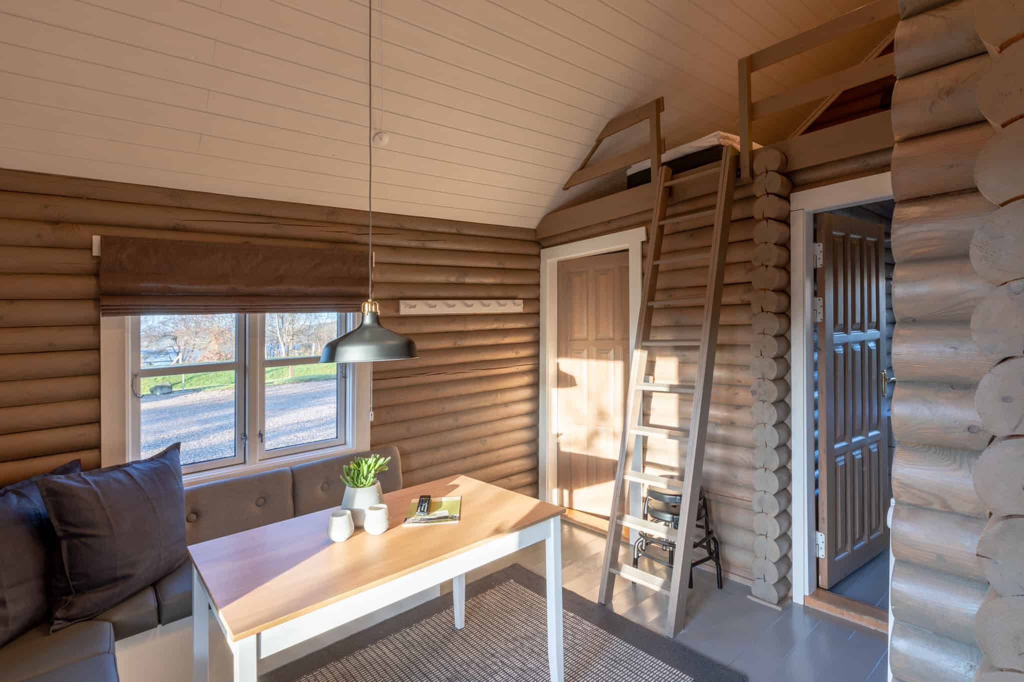 Loftstue i Knudhule Badehotel med rustikt træinteriør og hyggelig atmosfære.