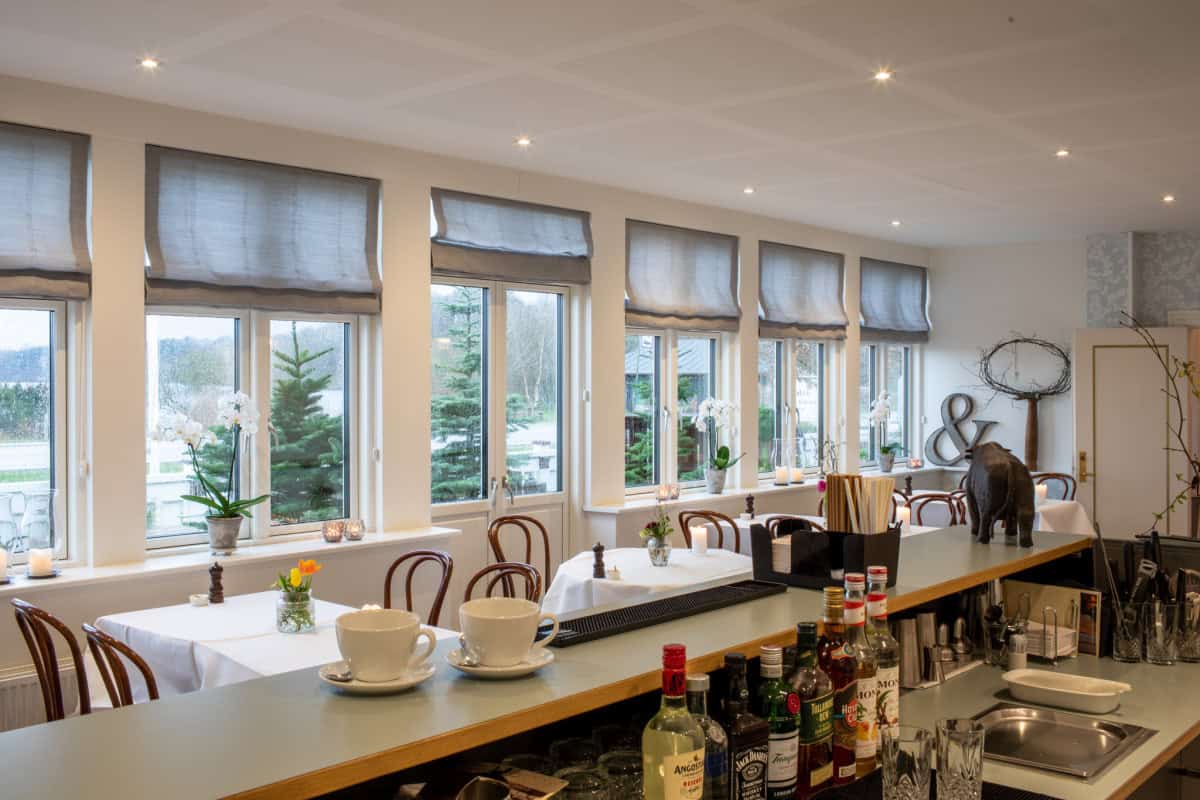 Moderne badehotel indendørsmiljø med store vinduer og hyggelig barområde i Danmark.