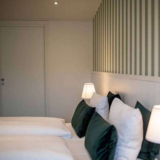 Lækkert hotelværelse med moderne indretning og hyggelig belysning, perfekt til afslapning ved Knudhule Badehotel.