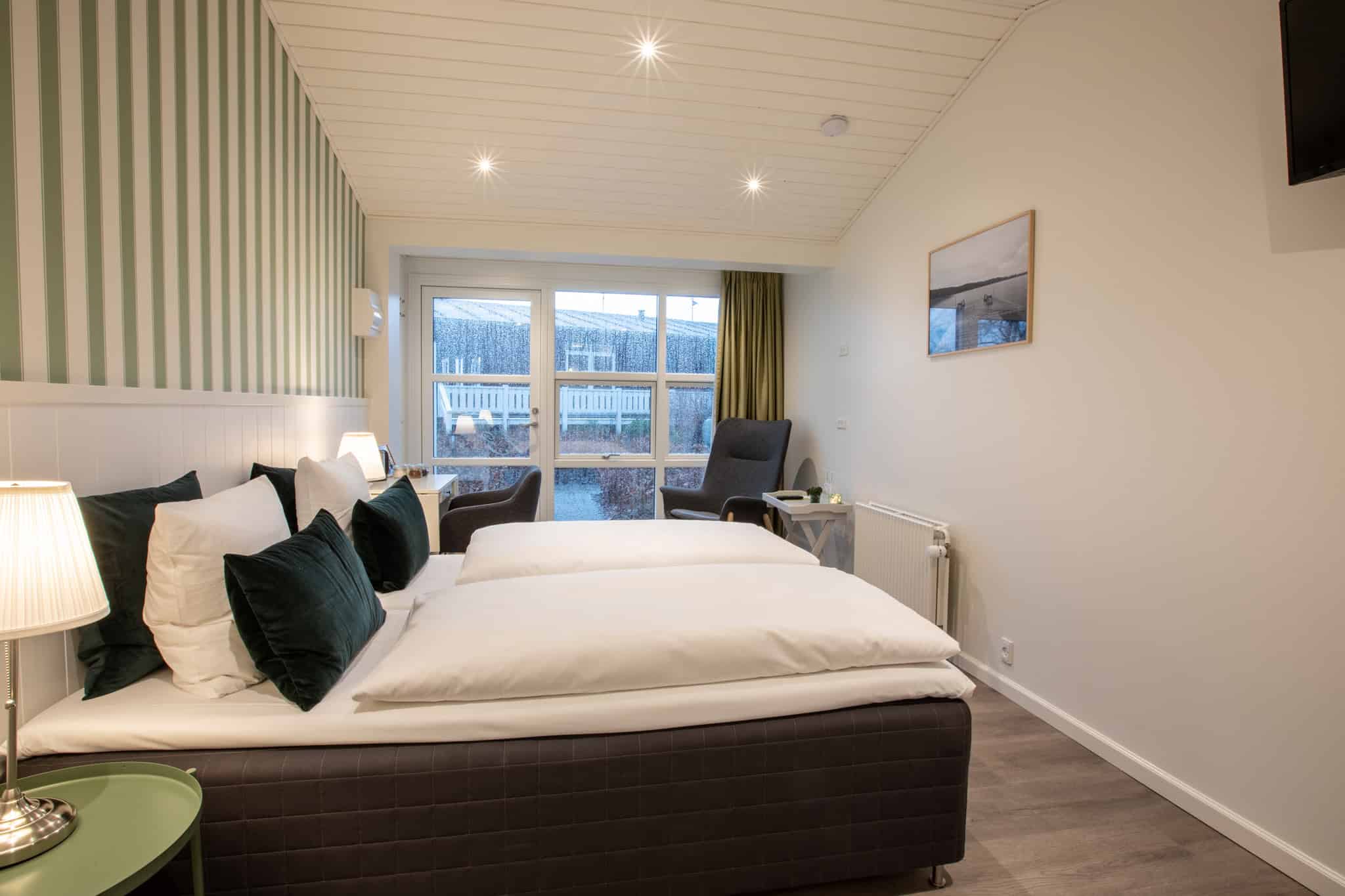 Komfortabel hotelværelse med hyggelig indretning og udsigt til haven.