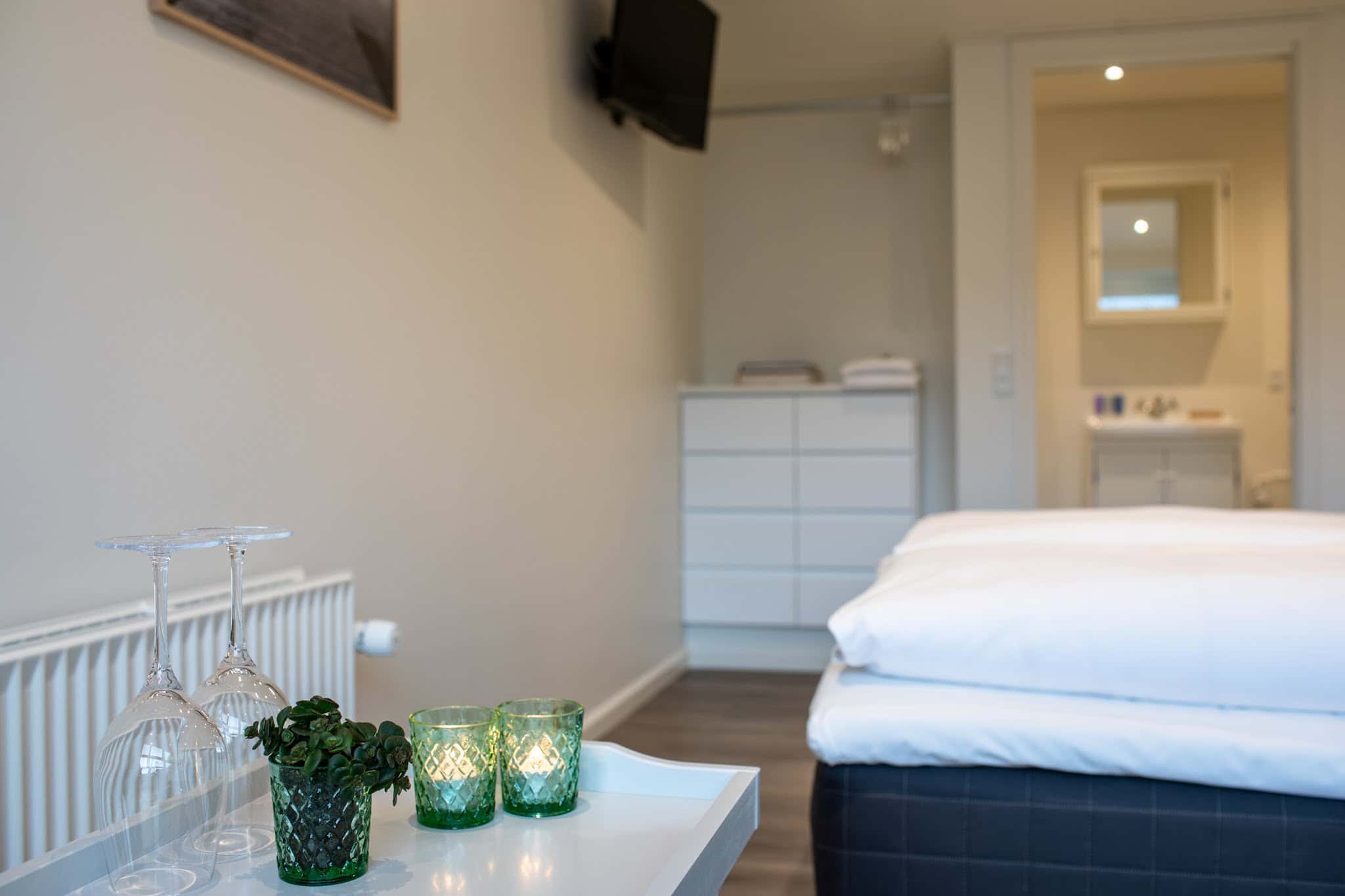 Rene hotelværelsesinteriør med moderne indretning og komfortable senge i naturskønne omgivelser.