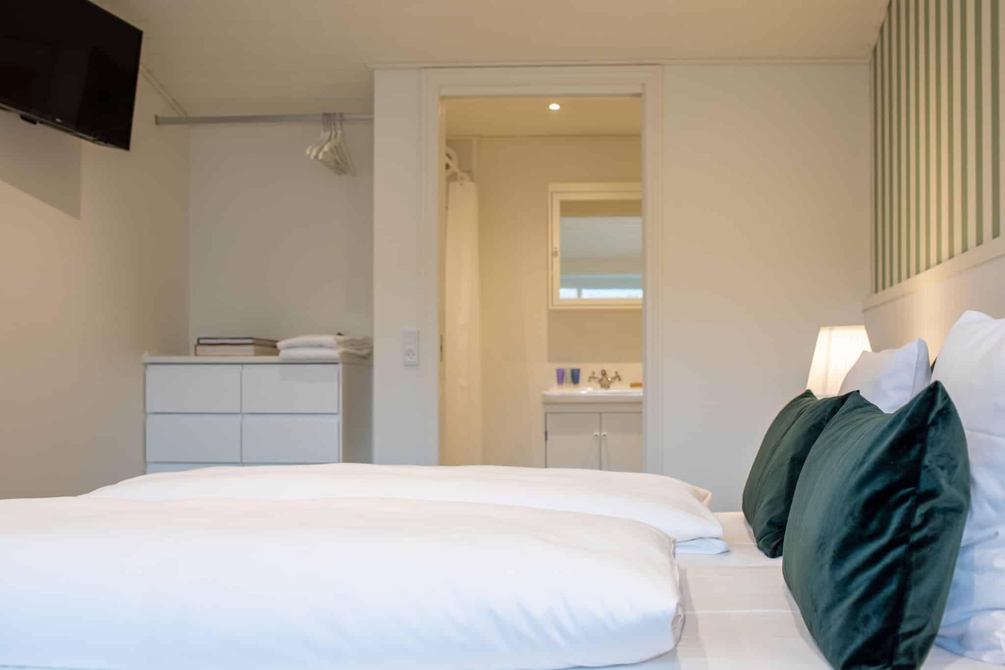 Lækkert værelse på Knudhule Badehotel med komfortable senge og moderne faciliteter.