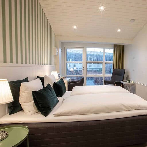 Lys indretning på Knudhule Badehotel med komfortabelt værelse og naturskøn udsigt.