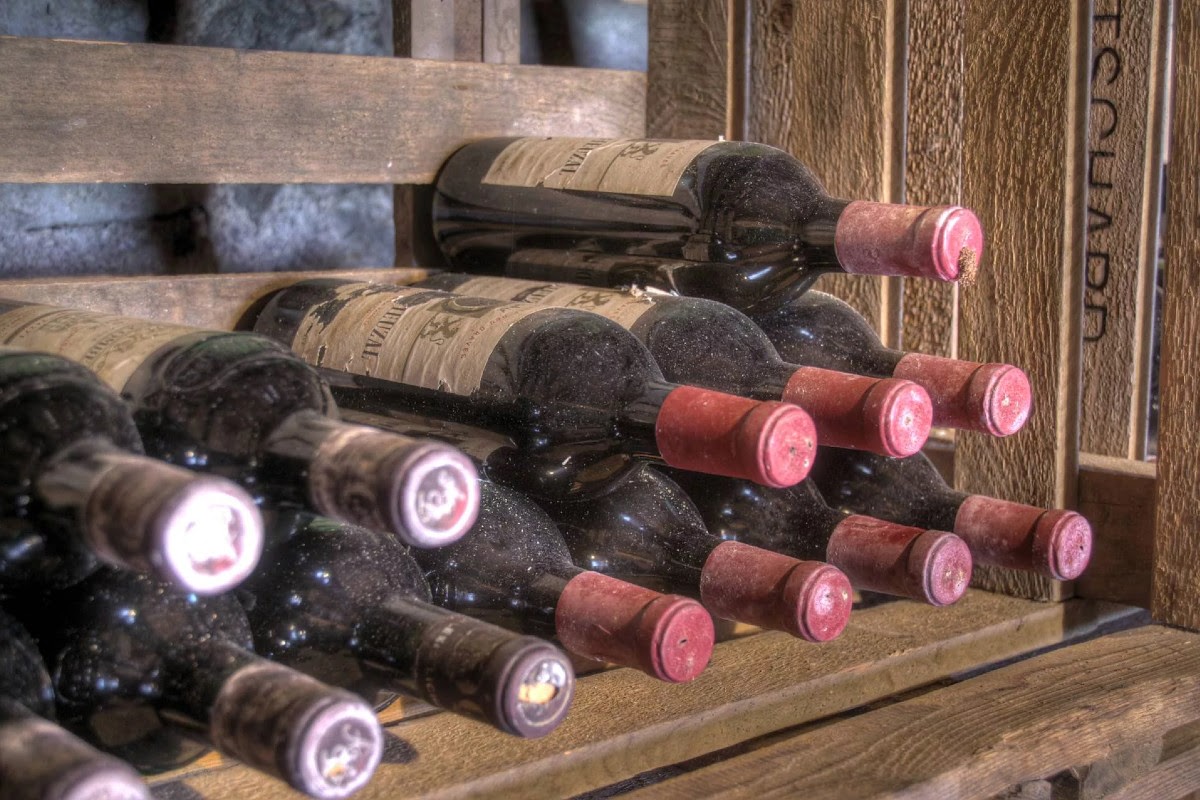 Flasker vin på lager i træskab, vinoplevelse på Knudhule Badehotel.