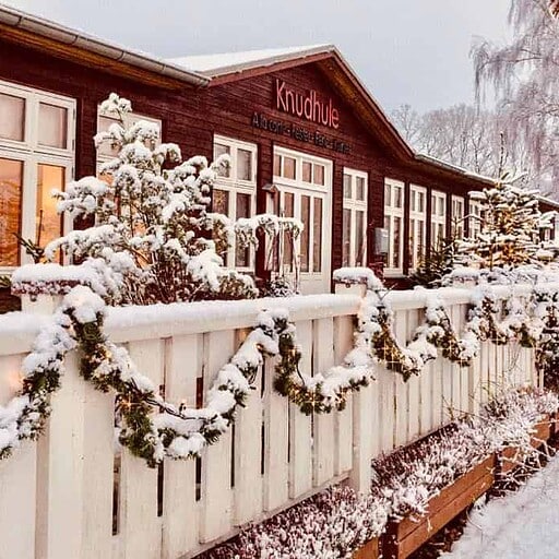 Knudhule Badehotel i sne, vinterbelysning og julestemning.