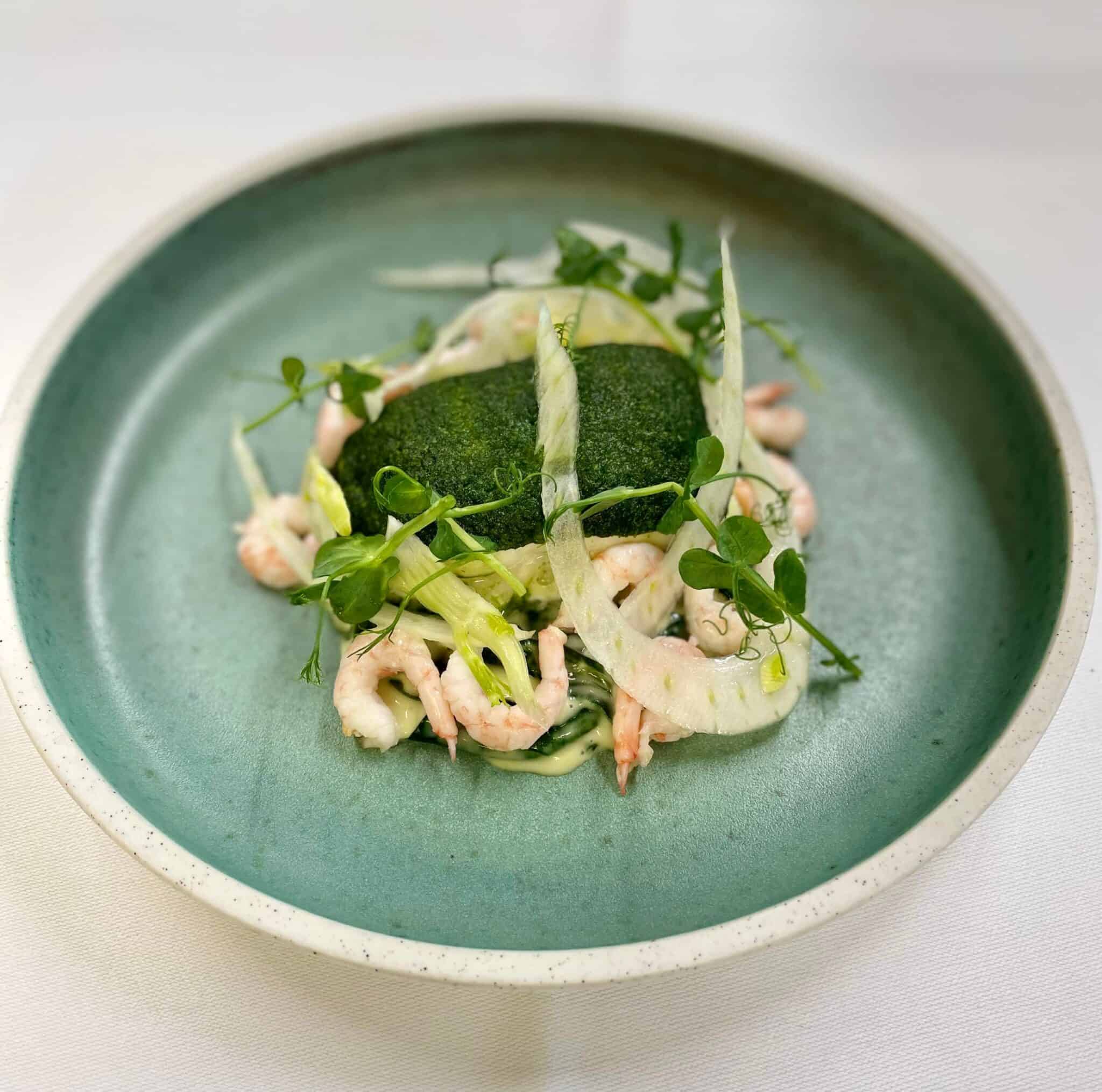 Frisk skaldyr med grønne urter på tallerken.