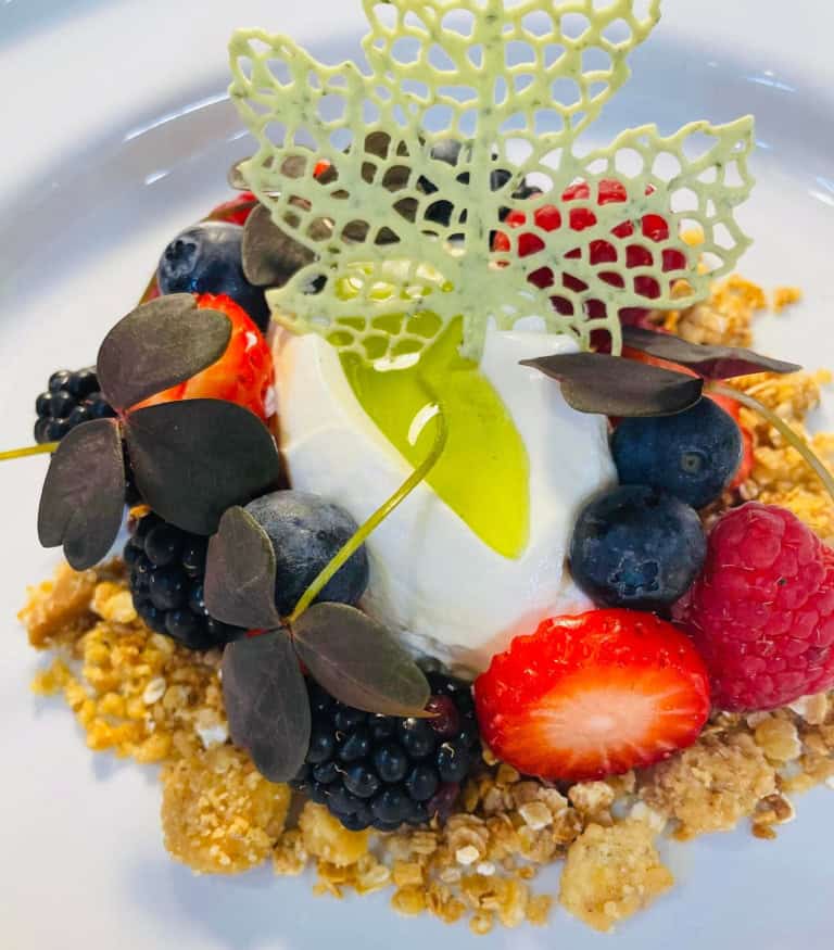 Frisk dessert med bær, yoghurt og sprød granola på Knudhule Badehotel.