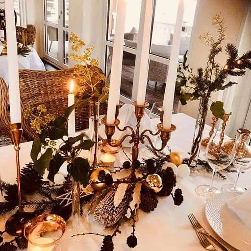 Elegance ved Knudhule Badehotel med rustikke lysestager og juledekorationer.