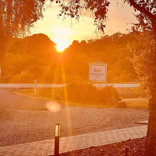 Fredelig hotelindgang ved solnedgang på Knudhule Badehotel i naturskønt omgivelser.