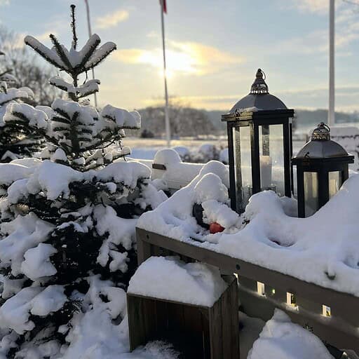 Snedækket julestjerne og lanterner ved Knudhule Badehotel i snevejret.