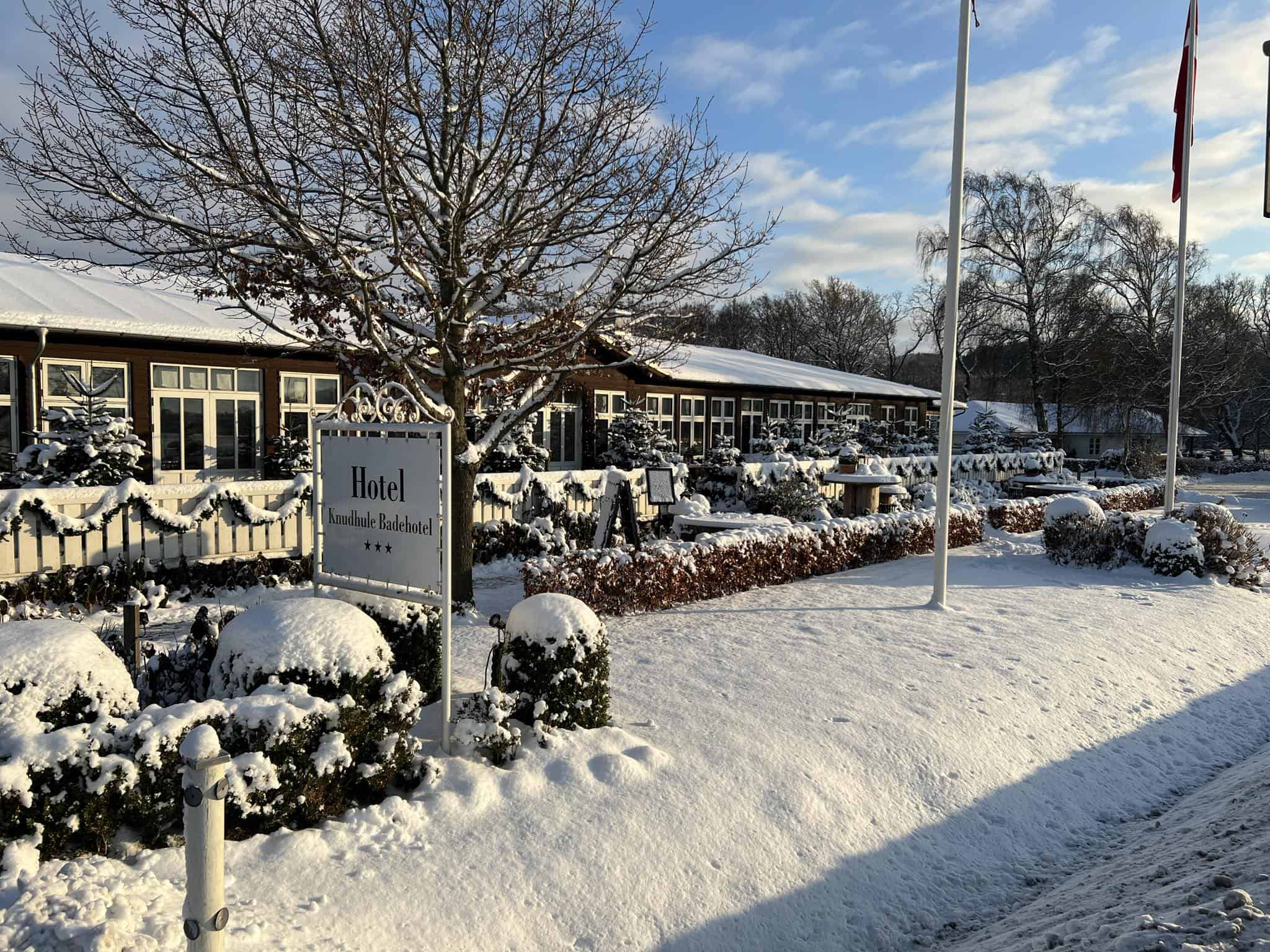 Knskudhule Badehotel i sneet, skøn vinterudsigt med hotelfacade og snedækkede omgivelser.