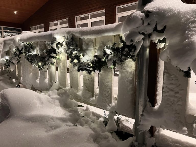Snedækket altan med juledekorationer ved Knudhule Badehotel om vinteren.