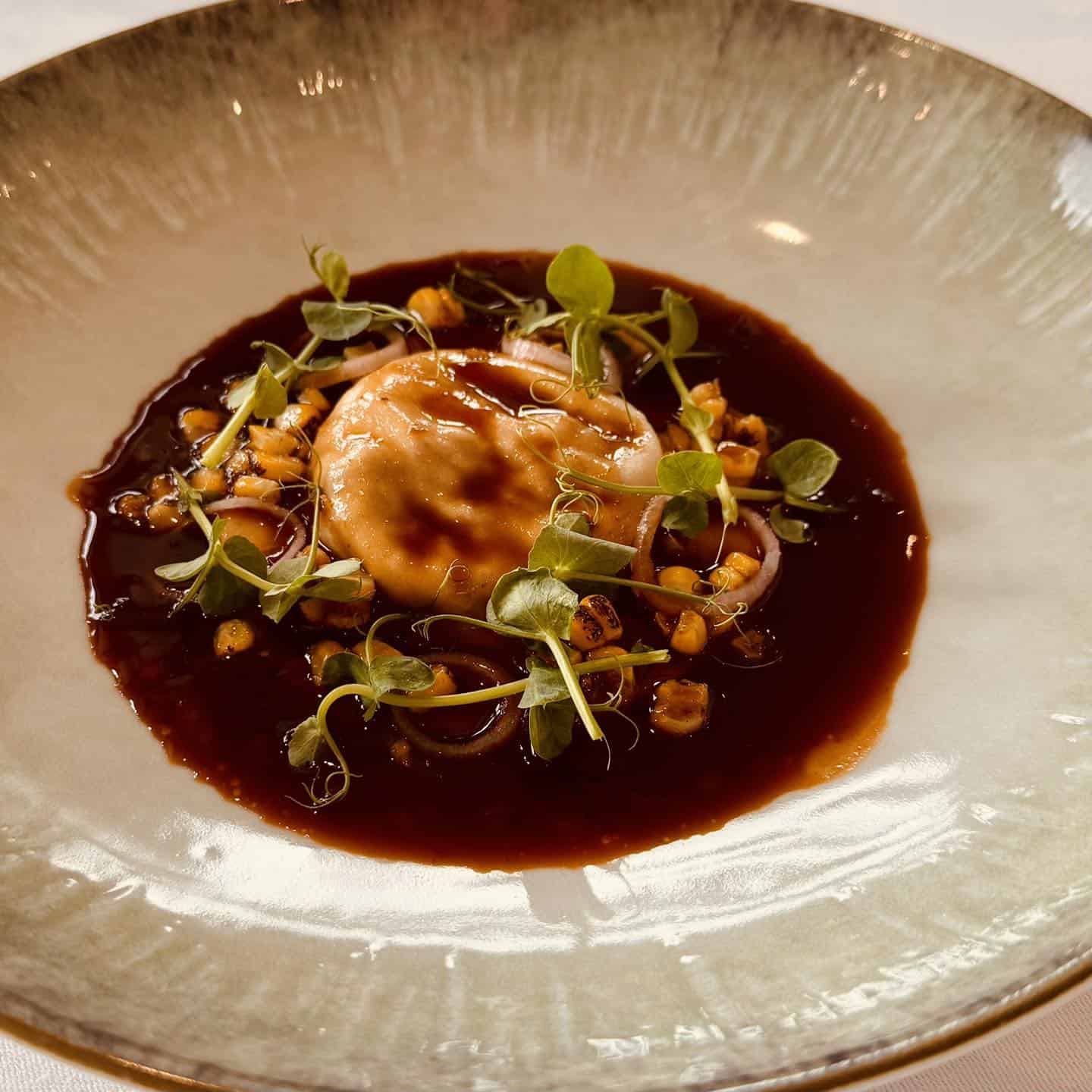 Luksuriøs gourmetret med muslinger, kokossauce og microgreens på Knudhule Badehotel.
