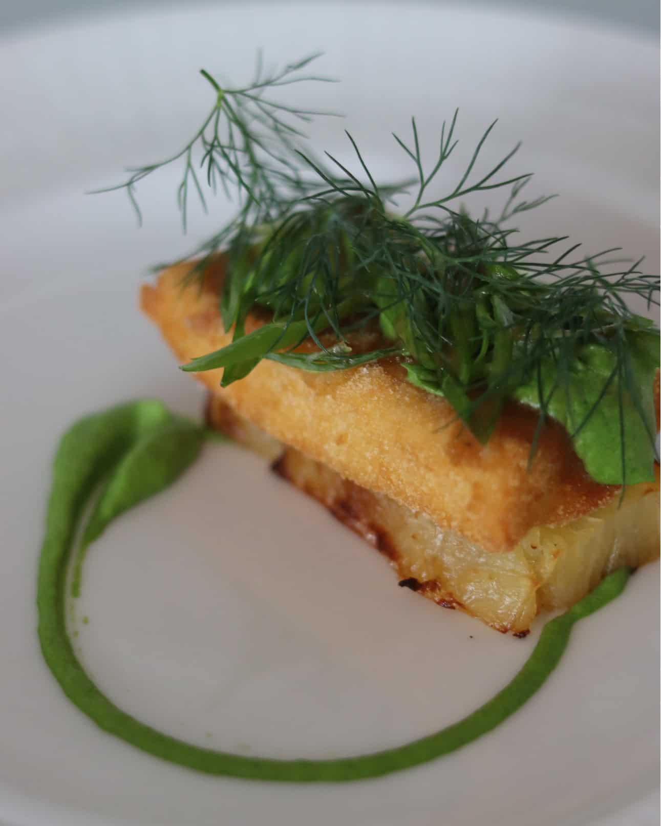 Delikat fiskeret med friske urter og grøn sauce - perfekt til afslapning på Knudhule Badehotel.