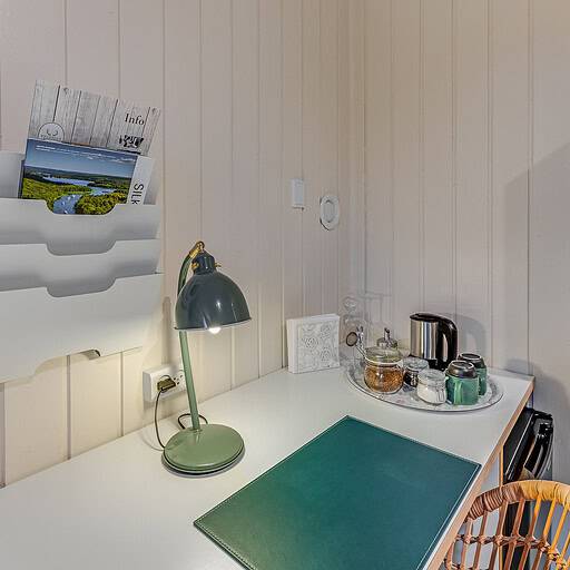 Badehotelindretning med hyggeligt køkkenhjørne og info-materialer, perfekt for afslappende ophold.