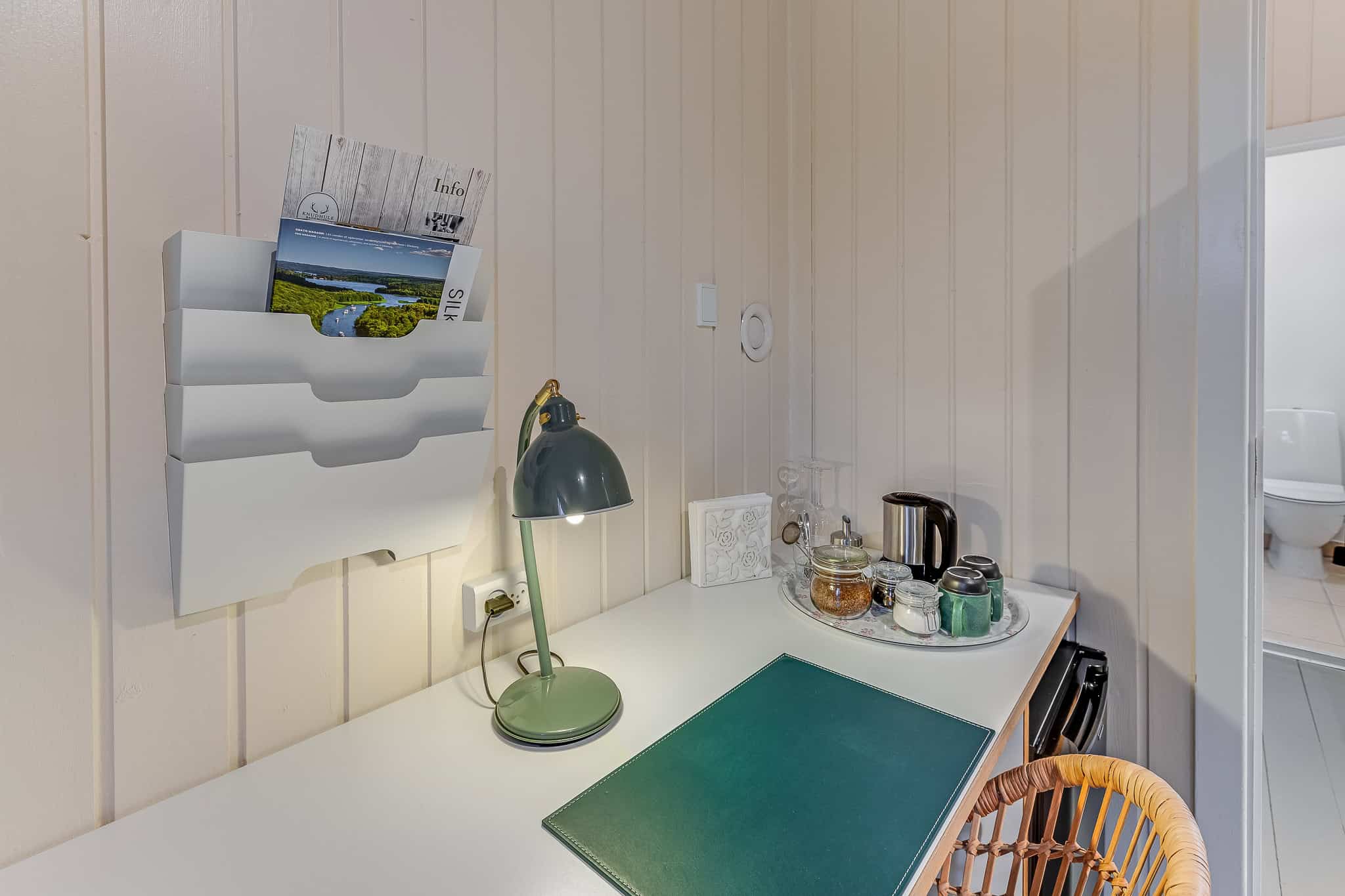 Badehotelindretning med hyggeligt køkkenhjørne og info-materialer, perfekt for afslappende ophold.