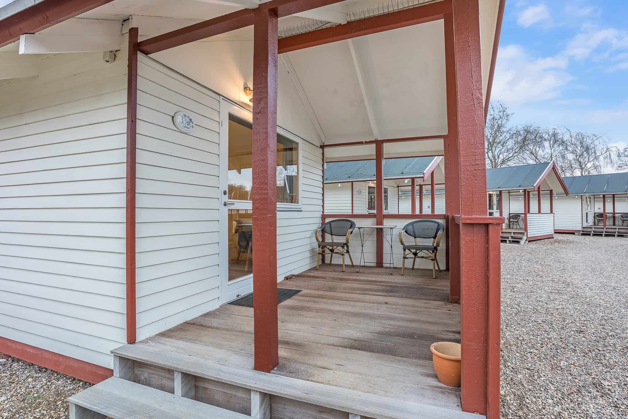Bekvem terrasse på Knudhule Badehotel med udsigt over ferieboliger og natur.