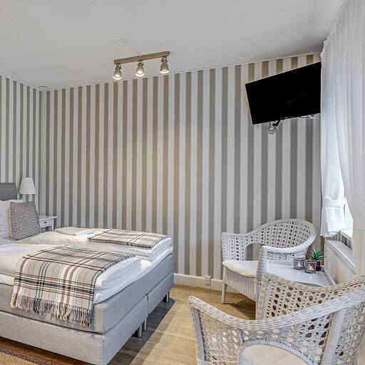 Hyggeligt hotelværelse med komfortable senge, moderne indretning og elegant atmosfære på Knudhule Badehotel.