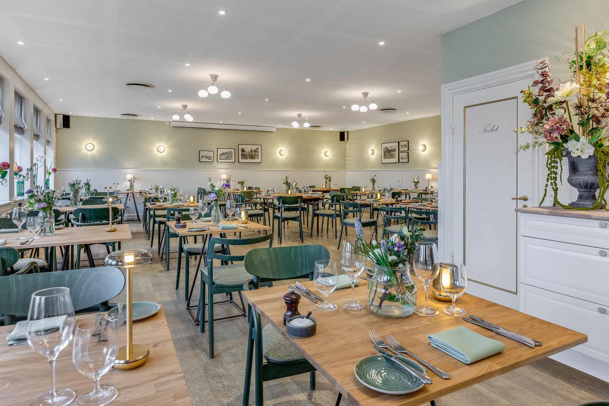 Lækker restaurantindretning på Knudhule Badehotel med hyggelige borde og blomster.