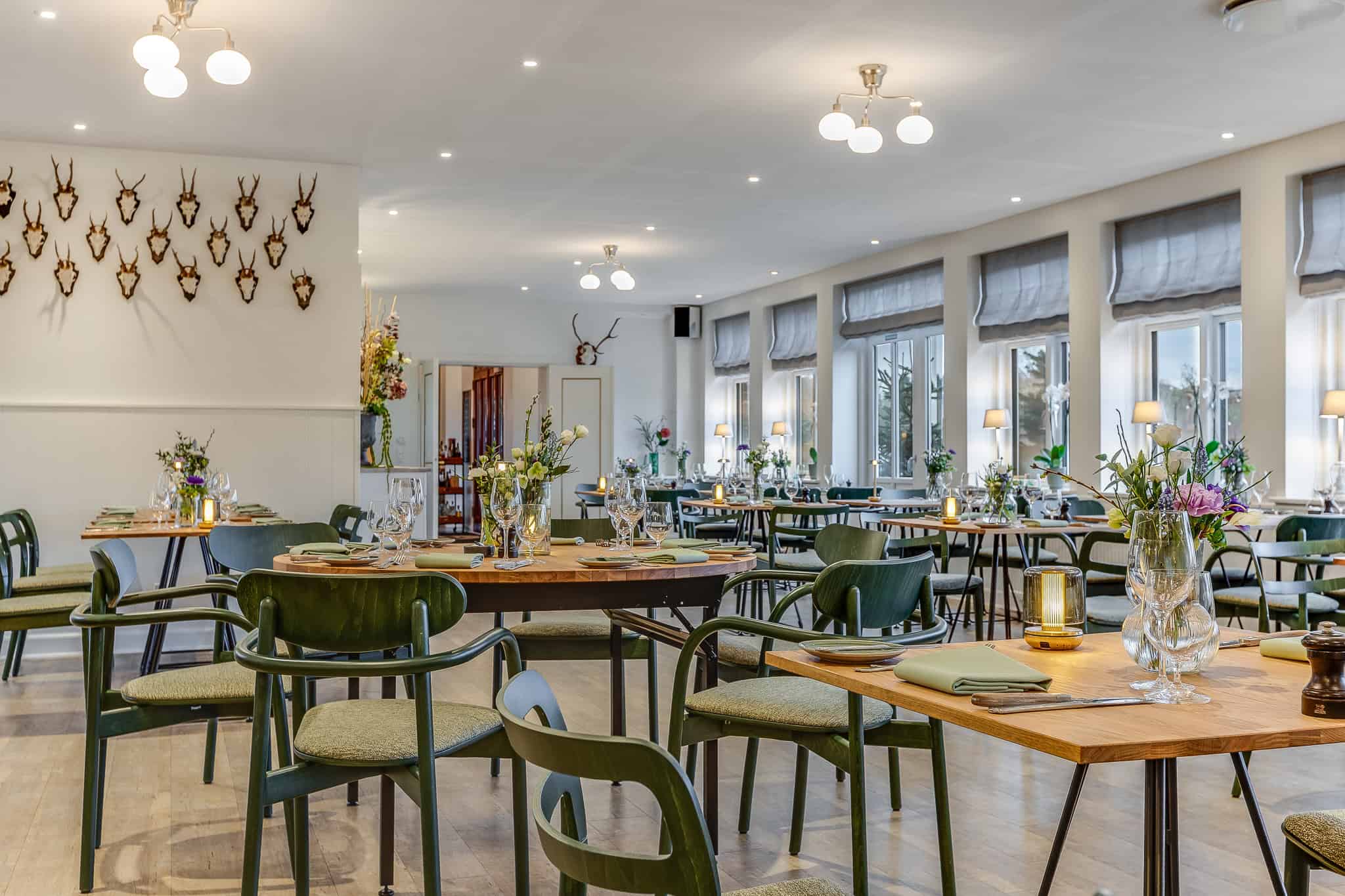 Elegant restaurant på Knudhule Badehotel med moderne stil og flotte blomsterdekorationer.