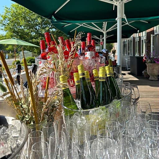 Champagne og sommerdrinks under parasol på udendørs terrasse ved Knudhule Badehotel.