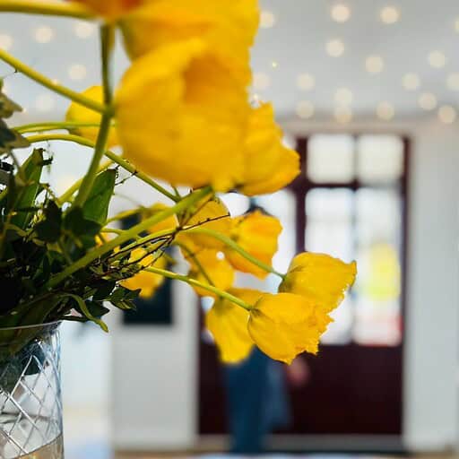 Blomster i badehotellets lobby med gule blomster og moderne indretning.